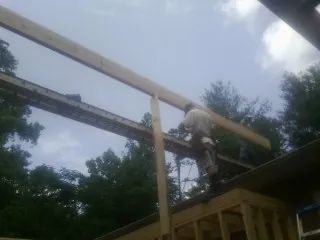 Carpenter setting a ridge beam over a new addition frame — Ice Dam Removal by Roofing Brothers in Longport